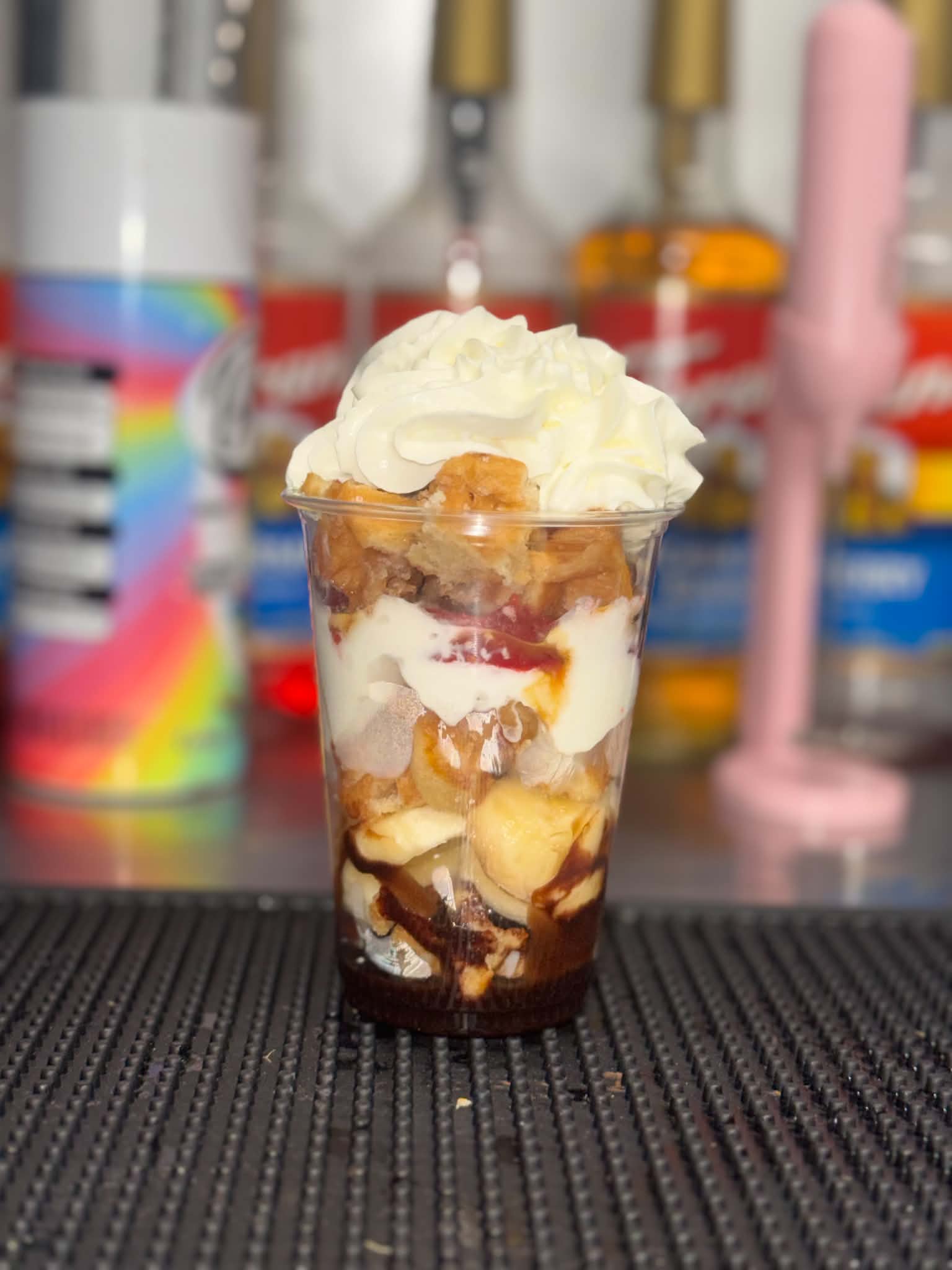 A layered banana, chocolate and cream dessert cup