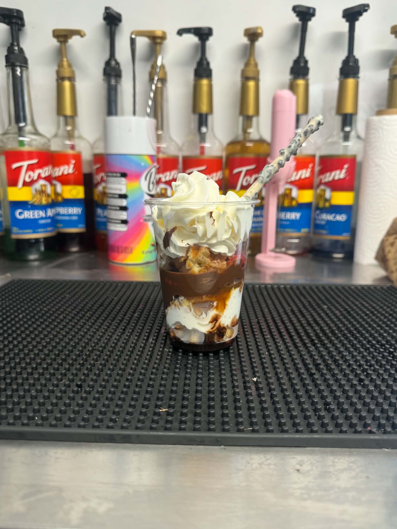 A chocolate and cream dessert cup finished with a chocolate stick