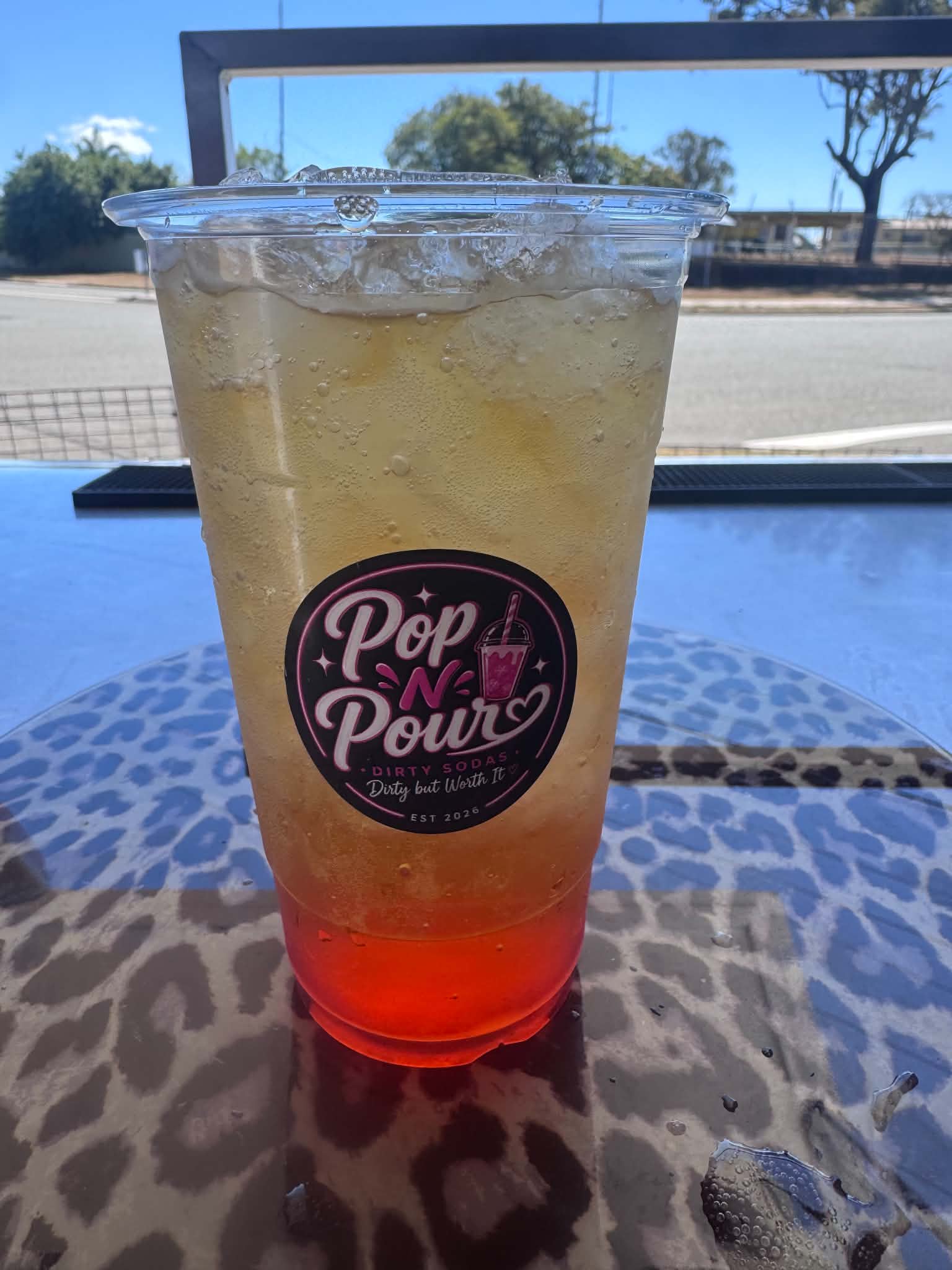 A chilled orange and gold Pop N Pour soda outdoors