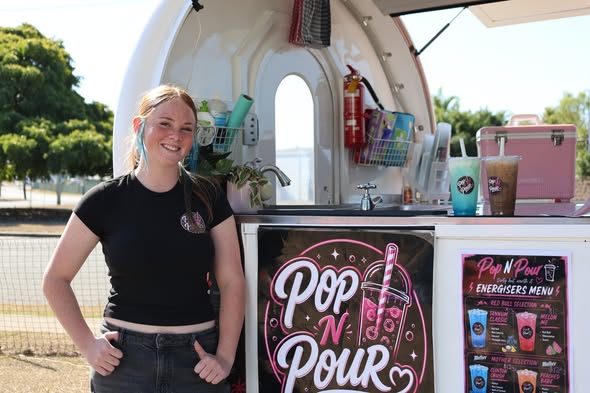 A smiling member of the Pop N Pour team beside the van